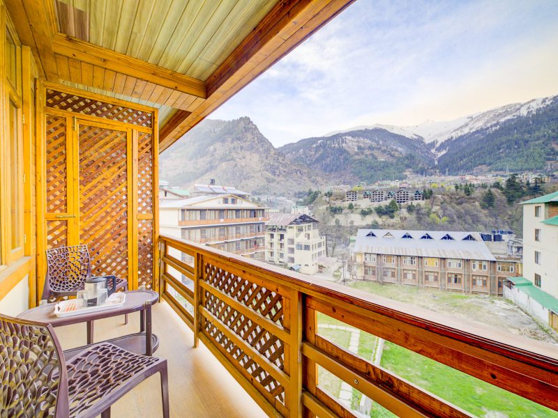 A stunning mountain vista greets you from the private balcony of a premium room at Hotel Grace Resort in Manali.