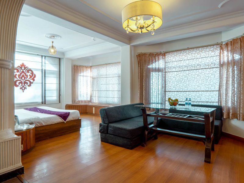 Spacious suite with comfortable seating area at AHR Windsor Hotel, Shimla.