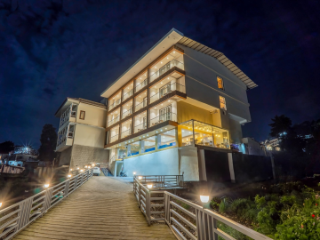 AHR Notting Hill Mussoorie hotel exterior illuminated at night with a lit pathway leading to the entrance.