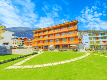 Daytime view of AHR Grace Resort and Spa, Manali, displaying its majestic wooden structure and lush green surroundings.